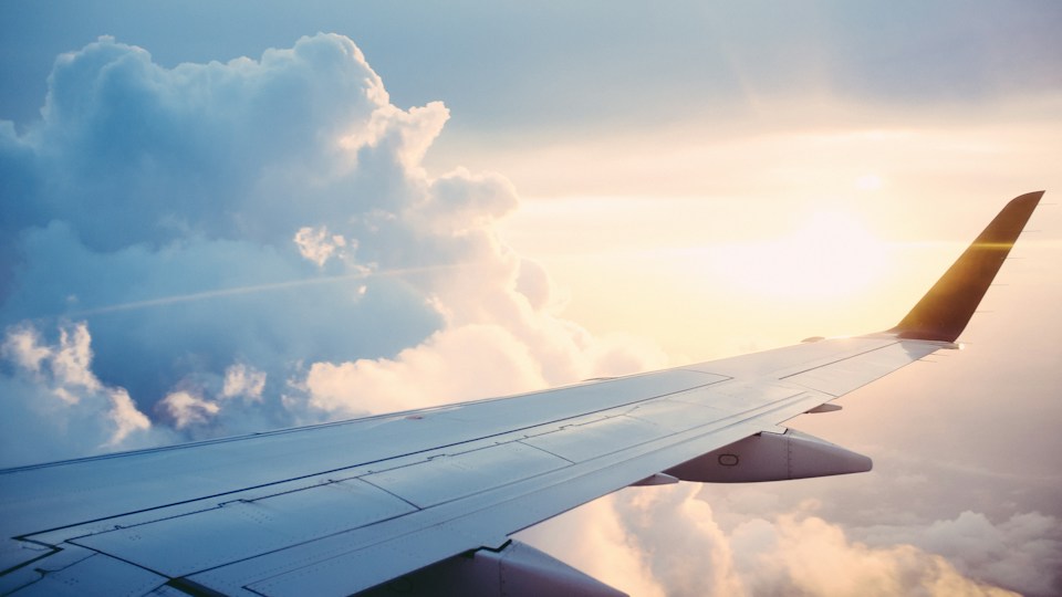 Passenger aircraft wing above the clouds