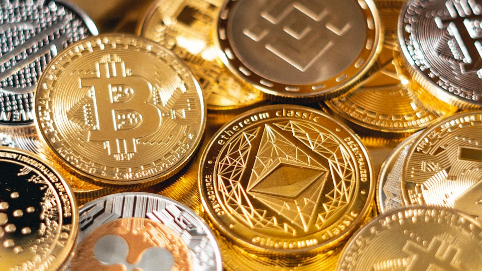 Physical cryptocurrency coins with an Ethereum coin in the foreground